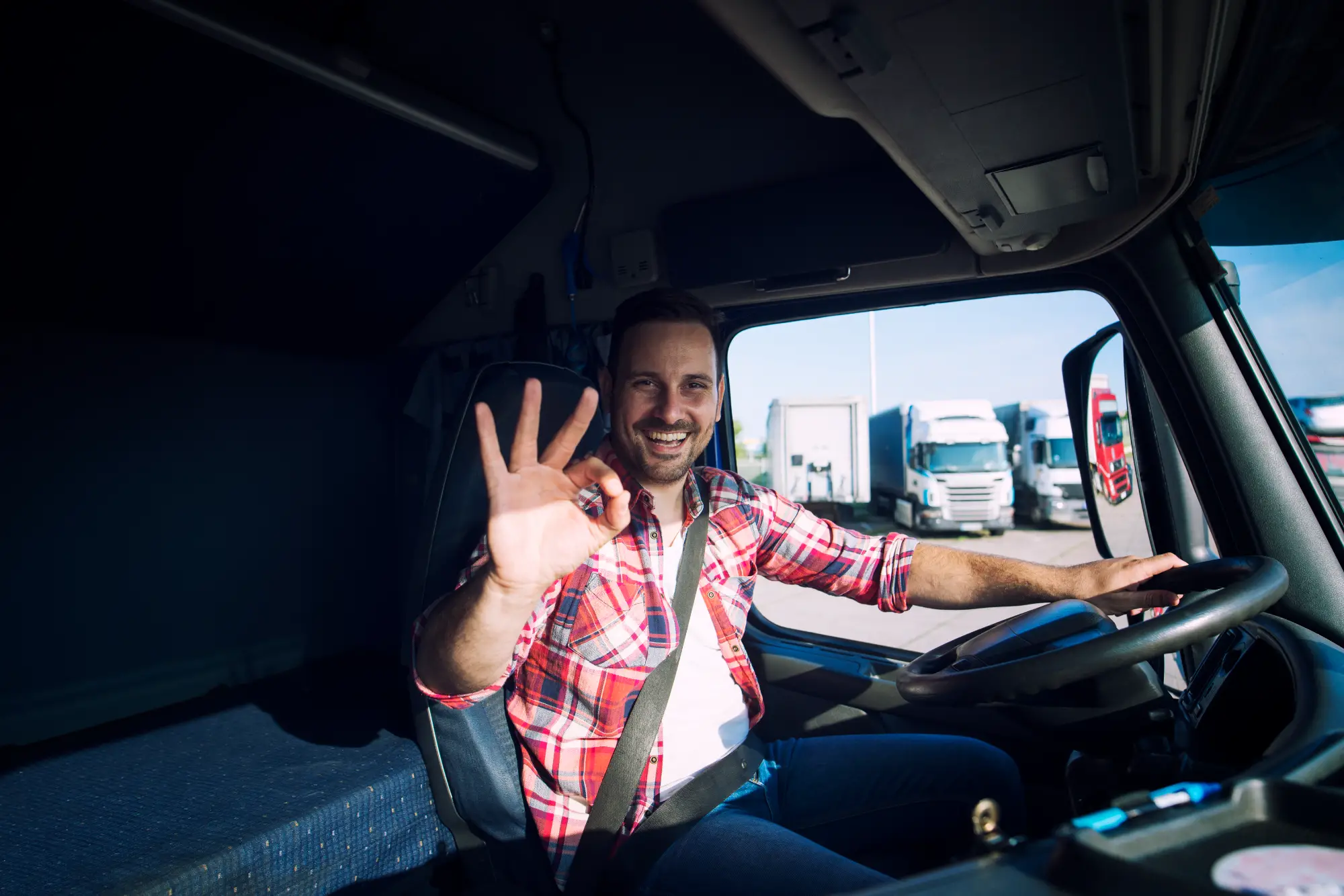 truck-driver-loving-his-job-showing-okay-gesture-sign-while-sitting-his-truck-cabin